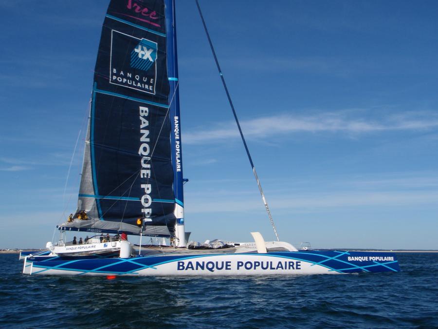 Banque Populaire having much trouble in getting its mainsail down. Note crowd on boom. Banque Populaire having much trouble in getting its mainsail down. Note crowd on boom.